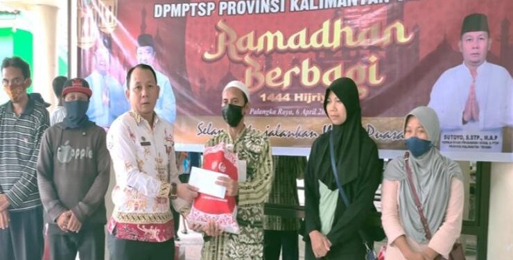 FOTO : IST/MATAKALTENG - Kepala Dinas PMPTS Kalimantan Tengah Sutoyo menyerahkan bantuan paket sembako kepada warga sebagai bentuk kepedulian terhadap sesama.