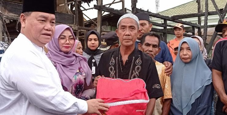 FOTO : DEVIANA/MATAKALTENG - Bupati Kotim Halikinnor saat menyerahkan bantuan kepada korban kebakaran di Kelurahan Baamang Hulu, Jumat 14 April 2023.