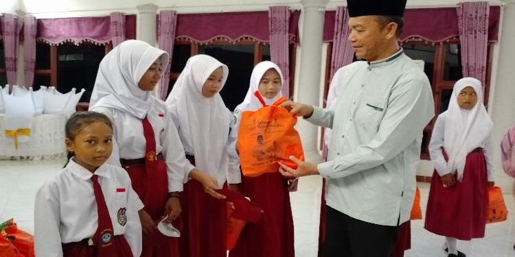 FOTO : AKH/MATAKALTENG - Bupati Sukamara Windu Subagio saat membagikan bingkisan untuk anak-anak sekolah kurang mampu.