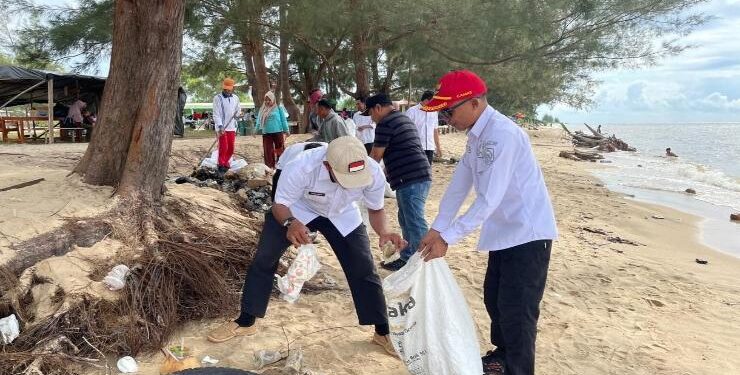 FOTO : IST/MATAKALTENG - Camat Teluk Sampit saat membersihkan sampah sisa pengunjung di Pantai Ujung Pandaran, Rabu 26 April 2023.