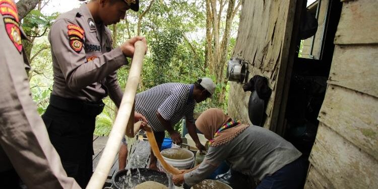 FOTO: HUMAS POLRES GUMAS/MATA KALTENG - Personel Polres Gumas saat melakukan distribusi air bersih kepada warga, Rabu 26 April 2023.