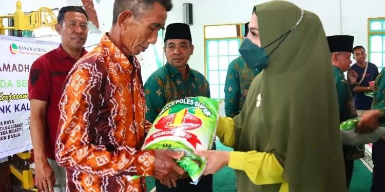 FOTO: PROKOM SERUYAN/MATA KALTENG - Wakil Bupati Seruyan, Iswanti (kanan) saat menyerahkan bantuan beras kepada masyarakat Desa Sungai Undang, Kecamatan Seruyan Hilir Timur akhir pekan lalu.