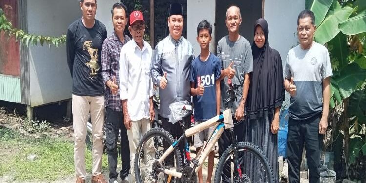 FOTO: ISTIMEWA/MATAKALTENG - Bupati Kotim, Halikinnor, bersama camat dan lurah setempat, pada saat menyerahkan bantusa sepeda kepada anak yang putus sekolah, Kamis 17 Mei 2023.