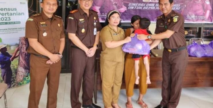 FOTO : KEJARI GUMAS/MATA KALTENG - Kepala Kejaksaan Negeri Gumas Sahroni (dua dari kanan) didampingi Kasi Intel Teguh Iskandar menyerahkan paket bantuan berupa kebutuhan pokok kepada masyarakat kurang mampu, Senin, 8 Mei 2023.