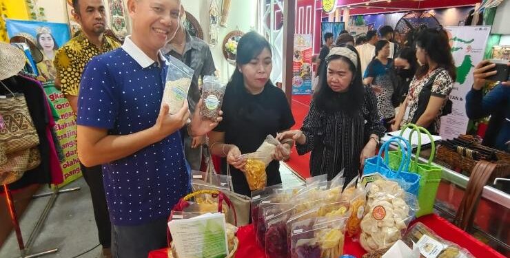 FOTO : DISKOMINFO SANTIK/MATA KALTENG - Bupati Gumas Jaya Samaya Monong didampingi Ketua TP-PKK Mimie Mariatie Jaya Samaya Monong, menunjukkan salah satu produk UMKM yang dipamerkan di stan Pemkab Gumas, pada gelaran Kalteng Expo 2023, Jumat, 19 Mei 2023.