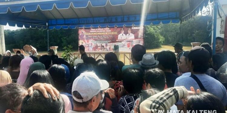 FOTO : SID/MATA KALTENG - Ratusan masyarakat mengantri untuk mendapatkan bahan pokok murah, saat pelaksanaan pasar penyeimbang bersubsidi berupa bazar atau operasi pasar pangan murah, di Taman Kota Kuala Kurun, Selasa 16 Mei 2023.