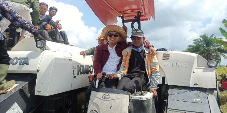 FOTO: ALDI/MATA KALTENG - Ketua DPRD Seruyan, Zuli Eko Prasetyo (kiri) saat mencoba menaiki mesin panen padi atau combine di Desa Pematang Limau, Kecamatan Seruyan Hilir beberapa waktu lalu.