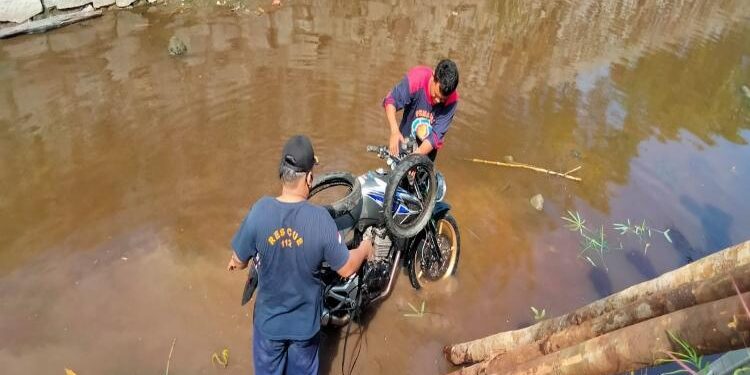 FOTO: RZL/MATAKALTENG - Petugas DPKP Kota Palangka Raya, pada saat berusaha mengevakuasi sepeda motor korban dari pengaringan.