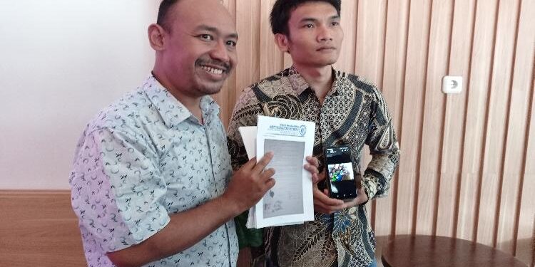 FOTO: RZL/MATAKALTENG - Kuasa hukum Nashir Hayatul Islam (kiri), bersama Hendrik Faisal Siburian, pada saat menunjukkan surat wasiat dan bukti foto penyerahan anak.