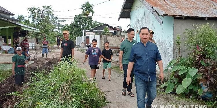 FOTO: DEVIANA/MATAKALATENG - Bupati Kotim Halikinnor bersama putra keduanya meninjau warga yang sedang gotong royong, Minggu 4 Juni 2023.