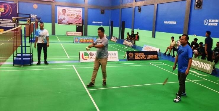 FOTO : SID/MATA KALTENG - Anggota DPRD Kabupaten Gumas Evandi (baju biru) dan Pimpinan Bank Kalteng Cabang Kuala Kurun Jeksenly bermain bulutangkis, pada pembukaan Turnamen Gilang Mas Open 2 tahun 2023, di GOR GGS Kuala Kurun, Senin, 5 Juni 2023 malam.