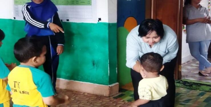 FOTO : ICEU PURNAMASARI/MATA KALTENG - Ketua Komisi III DPRD Kabupaten Gumas Iceu Purnamasari turut ikut membagikan makanan tambahan kepada anak-anak yang datang ke Posyandu Sinar Kasih Kuala Kurun, pekan lalu.