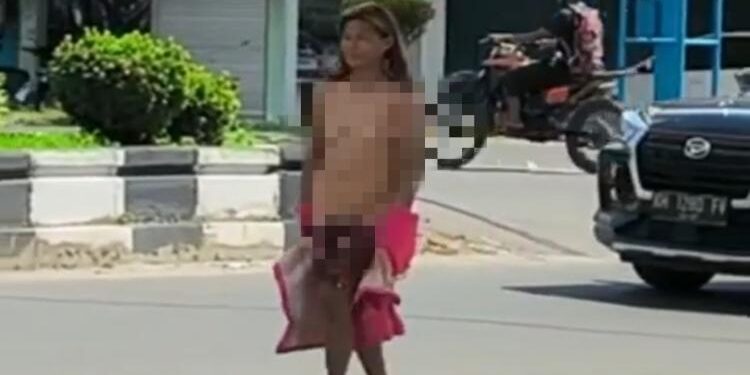 FOTO: IST/MATA KALTENG – Seorang perempuan yang diduga ODGJ saat berjalan di Jalan HM Arsyad Sampit. 