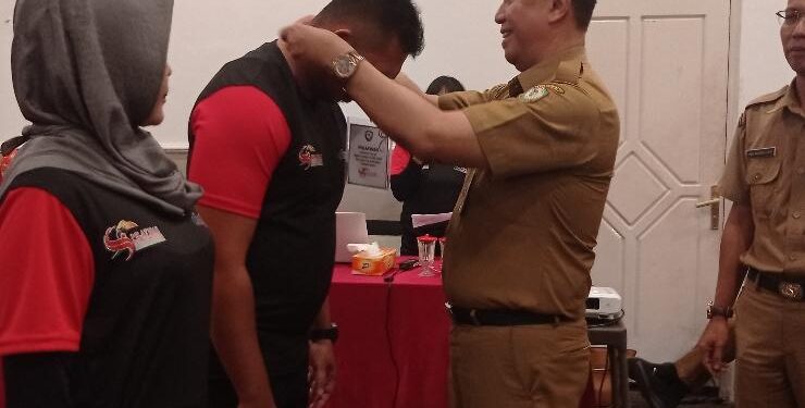 FOTO : DEVIANA/MATAKALTENG - Kadispora Kotim Wim RK Benung saat menyematkan tanda peserta, Selasa 13 Juni 2023.