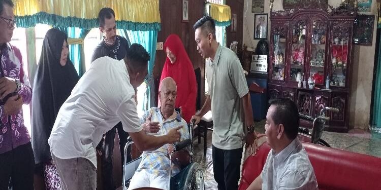 FOTO: DEV/MATAKALTENG - Bupati Kotim, Halikinnor, bersama putranya, Angga Aditya Nugraha, saat menyerahkan bantuan kursi roda kepada warga.
