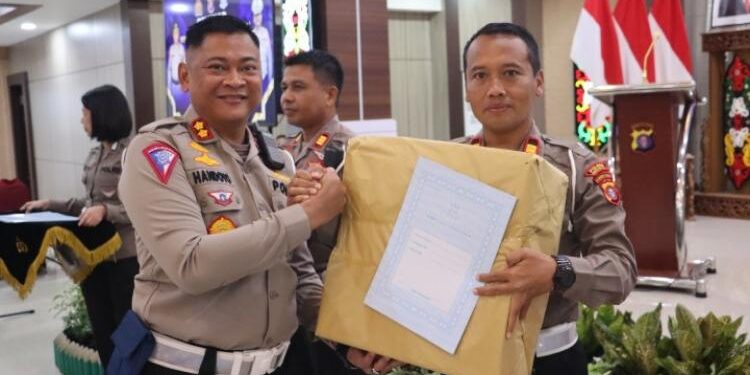 FOTO: MATAKALTENG - Dirlantas Polda Kalteng, AKBP RS Handoyo, saat menyerahkan hadiah kepada Kasat Lantas Polres Barsel, Iptu Juwito, di Mapolda setempat.