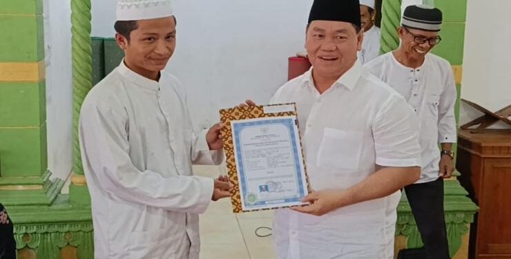 FOTO : RAFI/MATAKALTENG - Bupati Kotim Halikinnor menyerahkan ijazah negeri pertama untuk alumni Pondok Pesantren Darul Falah Mentaya Hilir Selatan, Sabtu 17 Juni 2023.