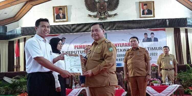 FOTO: DEVIANA/MATAKALTENG - Bupati Kotim Halikinnor saat menyerahkan SK kepada perwakilan PPPK guru, Selasa 27 Juni 2023.