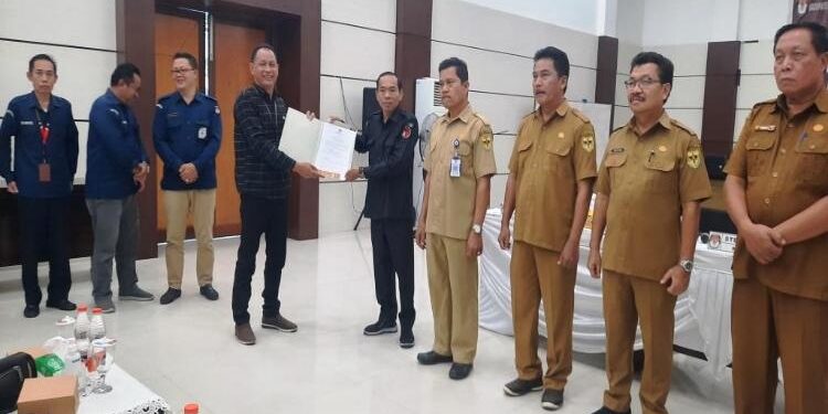 FOTO: SID/MATAKALTENG - Ketua KPU Kabupaten Gumas, Stepenson, saat menyerahkan berita acara hasil rapat pleno terbuka rekapitulasi DPT pemilu tahun 2024 ke pihak terkait, Selasa, 20 Juni 2023.