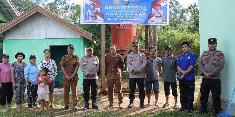FOTO: HUMAS POLRES/MATAKALTENG - Personel Polres Gumas dan Polsek Tewah bersama warga Desa Batu Nyapau, Kecamatan Tewah, usai penyerahan bantuan tandon air bersih, Kamis, 22 Juni 2023.