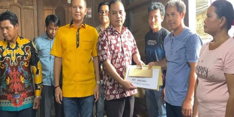 FOTO: EVANDI/MATAKALTENG - Anggota DPRD Kabupaten Gumas, Evandi, pada saat menyerahkan secara simbolis BLT DD kepada KPM, di Desa Tumbang Ponyoi, Kecamatan Kahayan Hulu Utara, belum lama ini.