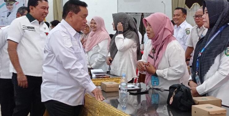 FOTO : DOK DEVIANA/MATAKALTENG - Bupati Kotim Halikinnor saat berbincang dengan Kepala BKAD Kotim Poraktina saat rapat evaluasi pembangunan di Aula Bappedalitbangda.