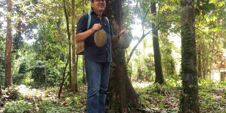 FOTO: IST/MATAKALTENG - Penjabat Bupati Kobar Budi Santosa saat Menyandau durian di Desa Panahan, Kecamatan Arut Utara.
