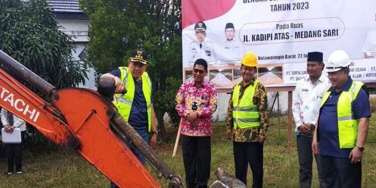 FOTO: IST/ MATAKALTENG - Pj Bupati Kobar Budi Santosa saat memecahkan kendi di alat berat tanda dimulainya kegiatan groundbreaking.