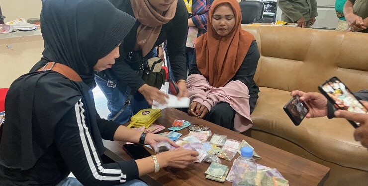 FOTO : DIAN/MATA KALTENG - Koordinator pengamen anak jalanan di Kota Sampit, Mesah (jilbab coklat tua) saat diamankan bersama barang bukti (uang setoran pengamen dan bukti pembelian emas dan perak), Senin 24 Juli 2023.