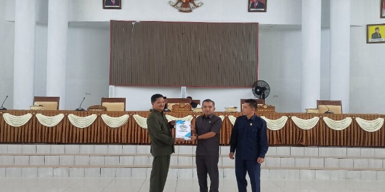 FOTO: ALDI/MATA KALTENG - Sekda Seruyan, Djainu'ddin Noor (kiri) saat menyerahkan dokumen Raperda tentang Pertanggungjawaban Pelaksanaan APBD Seruyan tahun anggaran 2022 kepada Ketua DPRD Seruyan, Zuli Eko Prasetyo (tengah) dalam rapat paripurna, Senin 24 Juli 2023.