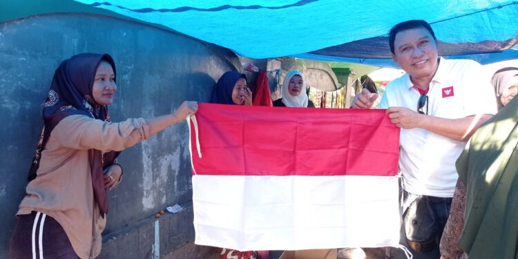 FOTO: DEVIANA/MATAKALTENG - Pembagian bendera merah putih oleh Pemkab Kotim kepada masyarakat, Minggu 30 Juli 2023.