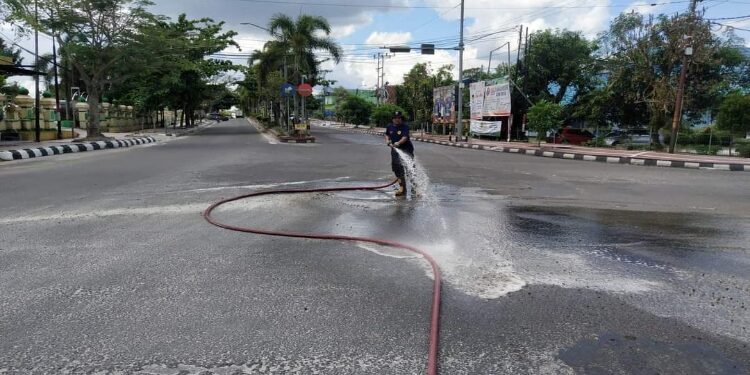 FOTO: IST/MATAKALTENG - Damkar Kobar bersihkan pasir yang menumpuk di Jalan Kota Pangkalan Bun.