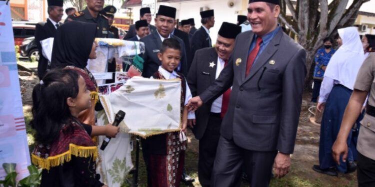 FOTO: IST/MATAKALTENG - Pj Bupati Kobar Anang Dirjo berdialog dengan salah satu pelajar usai upacara peringatan Hardiknas di halaman kantor bupati.