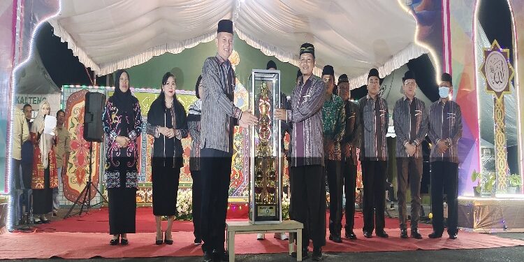 FOTO: DISKOMINFOSANTIK/MATAKALTENG - Bupati Gumas Jaya S Monong didampingi Wakil Bupati Efrensia LP Umbing, Kapolres AKBP Asep Bangbang Saputra, Kajari Sahroni, Plt Sekda Richard, menyerahkan piala juara umum untuk diperebutkan kafilah kecamatan, pada pembukaan MTQ ke-XVI dan FSQ ke-X tahun 2023, di Taman Kota Kuala Kurun, Senin, 7 Agustus 2023 malam.