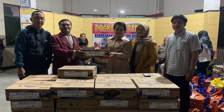 FOTO: MATAKALTENG - Ketua IMM Kota Palangka Raya, Bagues Yustonie, saat menyerahkan bantuan kepada Lurah Langkai, Sri Wanti.