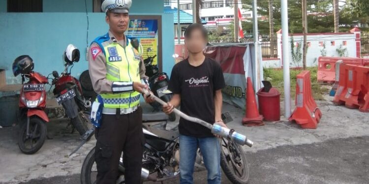 FOTO: RZL/MATAKALTENG - Pengguna knalpot brong saat melepaskan knalpotnya.