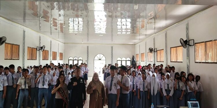 FOTO: RZL/MATAKALTENG - Ketua Tim Virtual Police Bidhumas Polda Kalteng, Ipda H Shamsudin, saat foto bersama para siswa dan guru, usai memberikan edukasi.