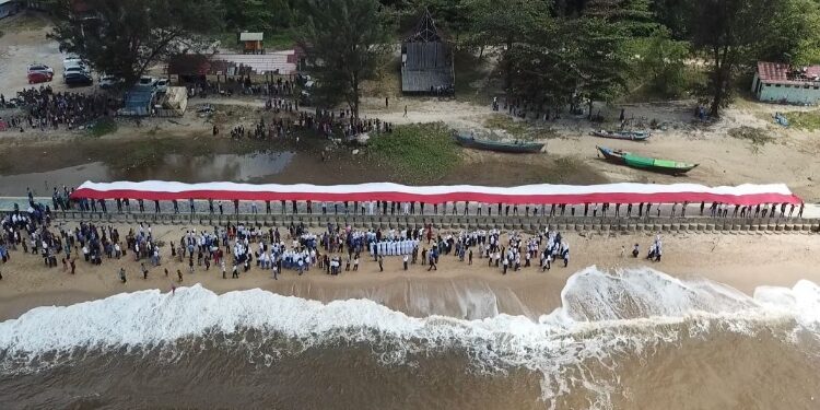 FOTO: IST/MATA KALTENG – Pembentangan bendera Merah Putih yang dilakukan oleh para nelayan, Kecamatan Teluk Sampit di tepi Pantai Ujung Pandaran untuk memperingati HUT ke-78 RI, Kamis, 17 Agustus 2023.