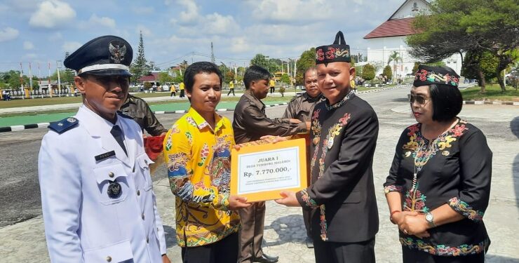 FOTO : SID/MATA KALTENG - Bupati Gumas Jaya S Monong bersama Wakil Bupati Efrensia LP Umbing menyerahkan piagam penghargaan kepada juara lomba desa tingkat kabupaten tahun 2023, yang diterima oleh Sekretaris Desa Tumbang Malahoi Efranatha, usai upacara memperingati HUT ke-78 Kemerdekaan RI, Kamis, 17 Agustus 2023.