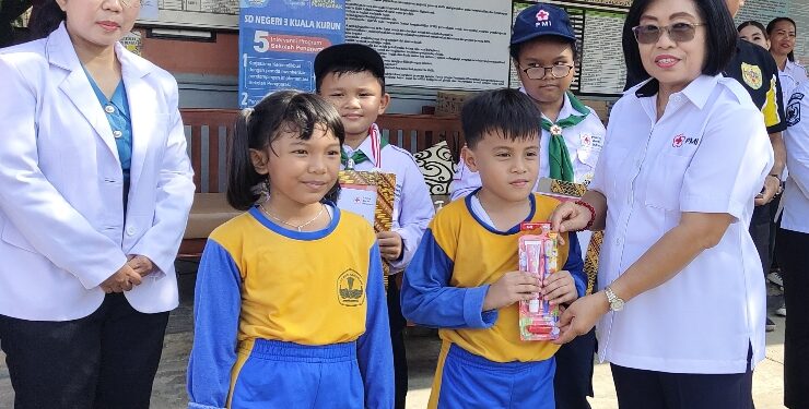 FOTO : SID/MATA KALTENG - Wakil Bupati yang juga selaku Ketua PMI Gumas Efrensia LP Umbing ketika membagikan ratusan paket sikat gigi kepada murid SDN 3 Kuala Kurun, Rabu, 16 Agustus 2023.