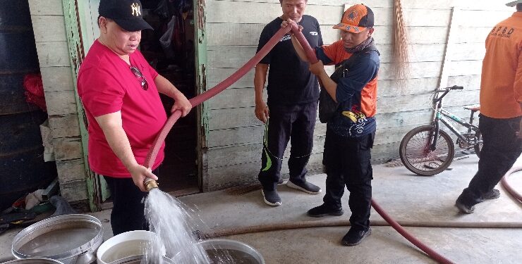 FOTO : DEVIANA/MATAKALTENG - Bupati Kotim Halikinnor bersama Camat MHS saat menyalurkan air bersih ke rumah warga di Desa Jaya Karet, Minggu 3 September 2023.