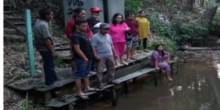 FOTO: MATAKALTENG - Ketua Komisi II DPRD Barsel Ensilawatika Wijaya (baju merah) saat melihat langsung kondisi air yang tercemar akibat limbah perusahaan di Desa Tamparak Layung Kecamatan Dusun Utara.