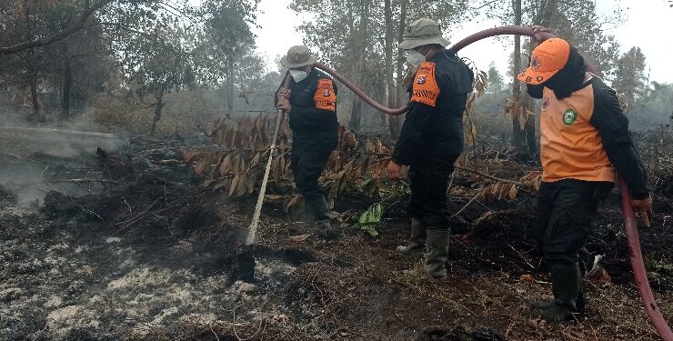 FOTO : DEVIANA/MATAKALTENG - Tim gabungan saat menembakkan racun api di lahan yang terbakar di Jalan Pramuka, Rabu 6 September 2023.