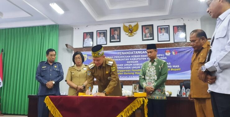 FOTO : SID/MATA KALTENG - Bupati Gumas Jaya S Monong didampingi Wakil Bupati Efrensia LP Umbing, Ketua Bawaslu Provinsi Kalteng Satriadi, Ketua KPU Gumas Stepenson serta Ketua Bawaslu Gumas Yepta H Jinal, menandatangani NPHD dalam rangka penyelenggaraan pilkada tahun 2024, di ruang rapat lantai 1 kantor bupati, Senin, 11 September 2023.