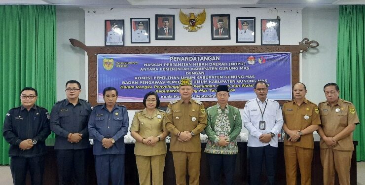 FOTO : DPRD GUNUNG MAS/MATA KALTENG - Ketua DPRD Kabupaten Gumas Akerman Sahidar (tiga dari kiri) menghadiri kegiatan penandatanganan NPHD penyelenggaraan pilkada tahun 2024, pekan lalu.