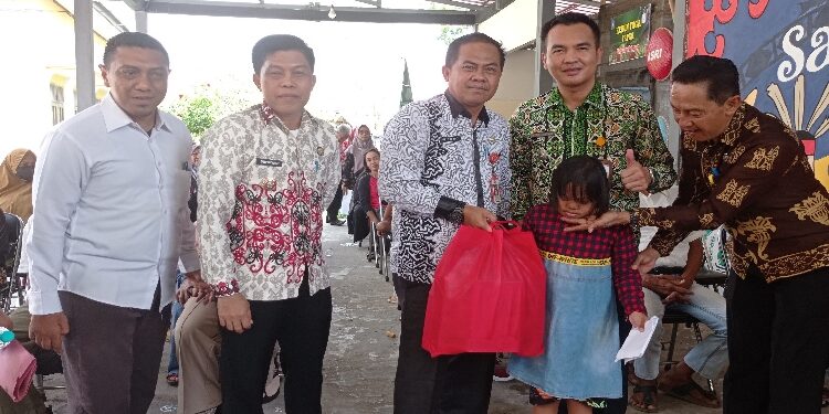 FOTO: DEVIANA/MATAKALTENG - Kadinsos Wiyono dan Camat MBK Eddy H. Setiadi saat menyerahkan bantuan atensi, Kamis 21 September 2023.