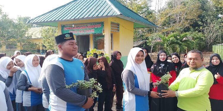 FOTO: AKH/MATAKALTENG - Kepala DLH Sukamara saat menyerahkan bunga ke siswa MAN 1 Sukamara.