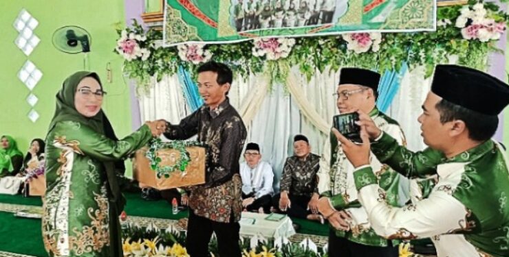 FOTO : IST/MATAKALTENG - Ketua LKKNU Barsel Hj. Yangsi Hartini menyerahkan bantuan sosial bagi Mualaf.