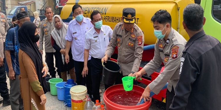 FOTO: RZL/MATAKALTENG - Wakapolresta Palangka Raya, AKBP Andiyatna, saat menyalurkan air bersih kepada warga.