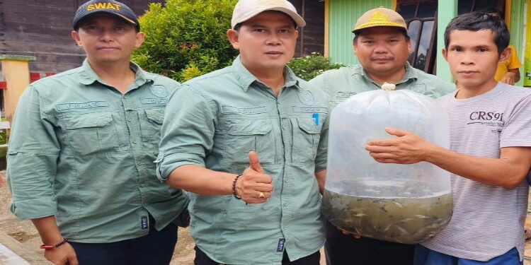 FOTO: DPKP GUMAS/MATA KALTENG  - Kepala DPKP Kabupaten Gumas Eigh Manto (dua dari kiri) ketika menyerahkan bantuan benih ikan patin, pakan benih dan pakan lanjutan kepada pembudidaya ikan, pekan lalu.